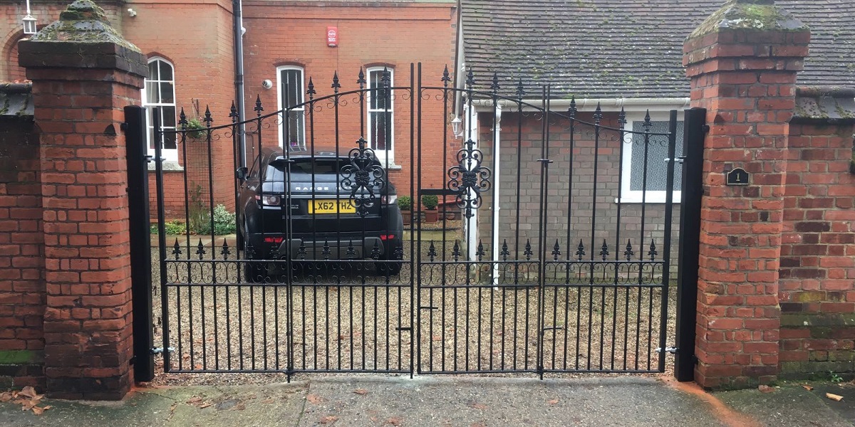 Traditional wrought iron estate gates with a bi folding design