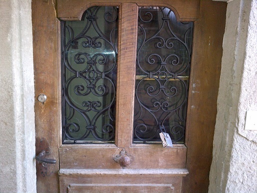Ornate traditional wooden door with wrought iron scrollwork