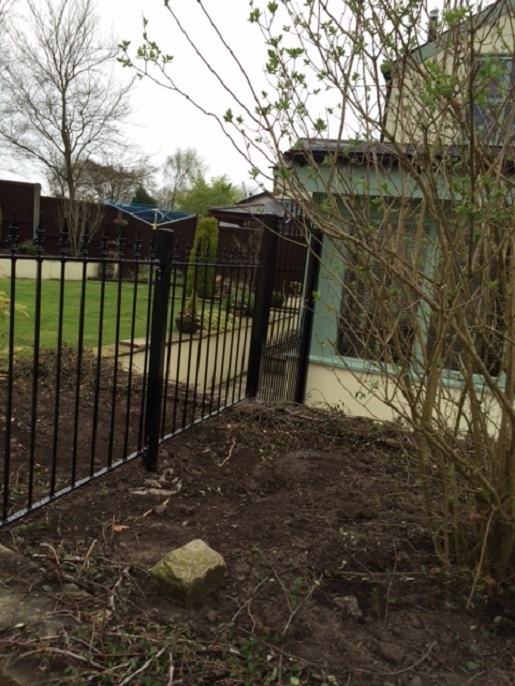 Saxon fence panels installed across flower bed to secure the garden