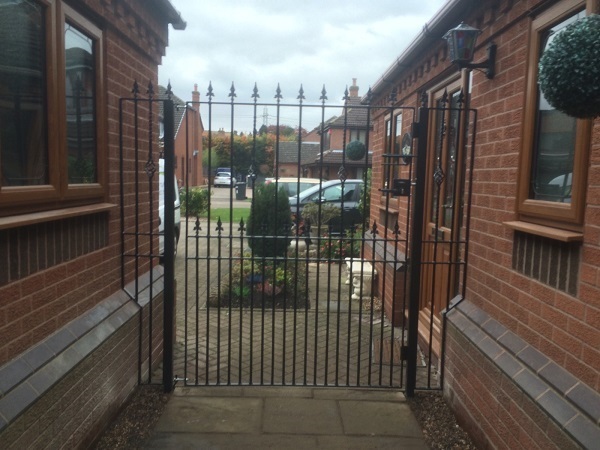 Small infill metal fence panels fitted to each side of a pedestrian access gates
